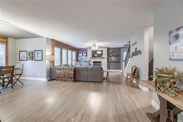 5204 W 166th St, Overland Park, KS 66085 - living room with baseboards, stairway, a fireplace, wood finished floors, and a ceiling fan