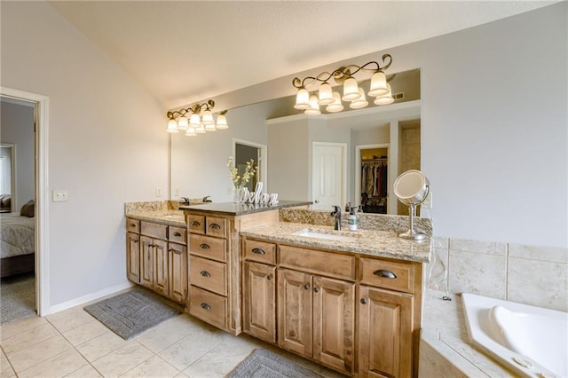 5204 W 166th St, Overland Park, KS 66085 - ensuite bathroom with double vanity, tiled bath, tile patterned flooring, lofted ceiling, and baseboards