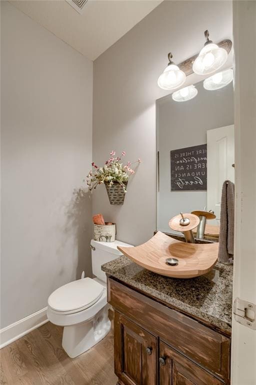 5204 W 166th St, Overland Park, KS 66085 - half bathroom featuring vanity, wood finished floors, toilet, and baseboards