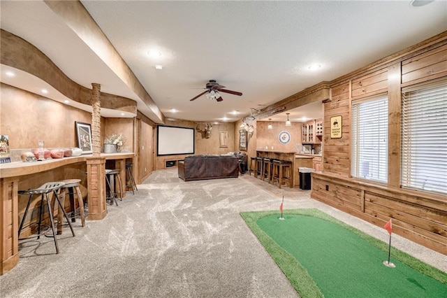 5204 W 166th St, Overland Park, KS 66085 - playroom featuring carpet, wooden walls, ceiling fan, bar area, and recessed lighting