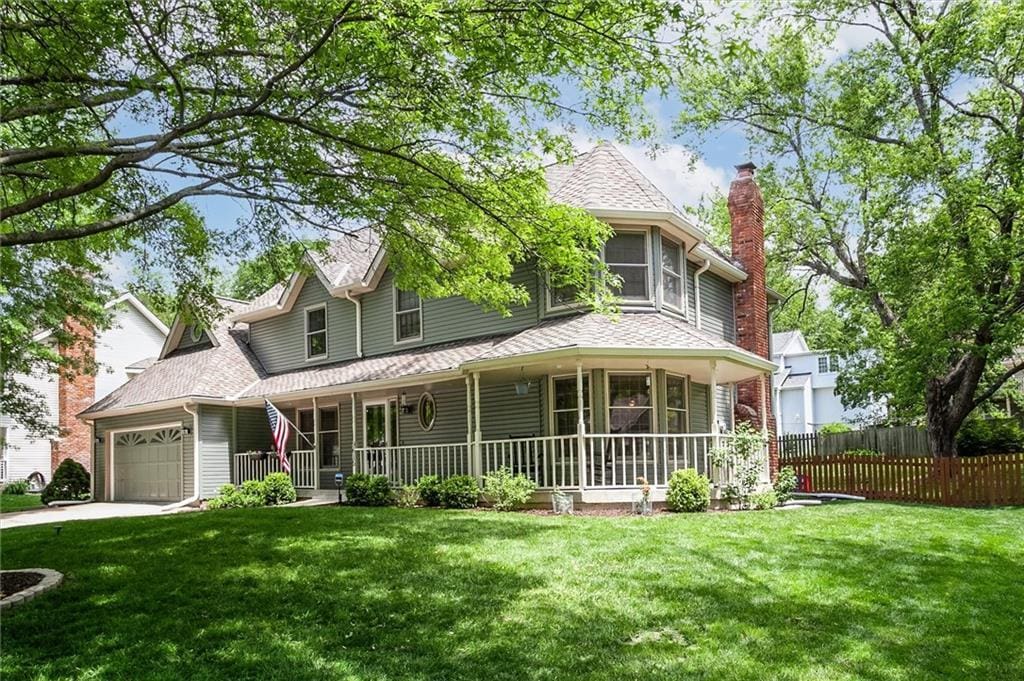 9615 N Virginia Ave, Kansas City, MO 64155 - victorian-style house with covered porch, a garage, a chimney, roof with shingles, and driveway