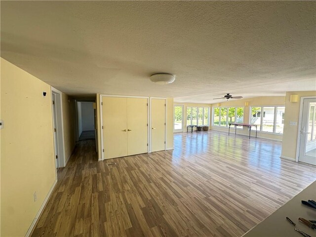 17795 K Hwy, Saint Joseph, MO 64505 - unfurnished living room with wood finished floors, a textured ceiling, a ceiling fan, and baseboards