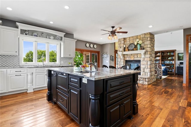 15405 161st St, Bonner Springs, KS 66012 - kitchen featuring a ceiling fan, white cabinets, a stone fireplace, and recessed lighting