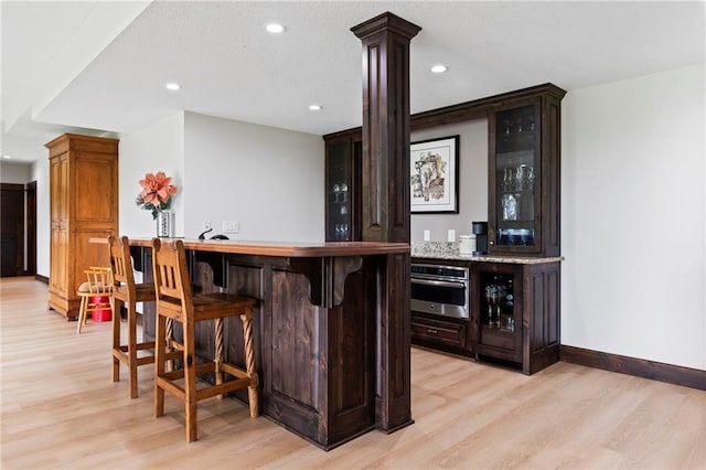 15405 161st St, Bonner Springs, KS 66012 - indoor dry bar with stainless steel oven, light wood-style floors, decorative columns, and recessed lighting