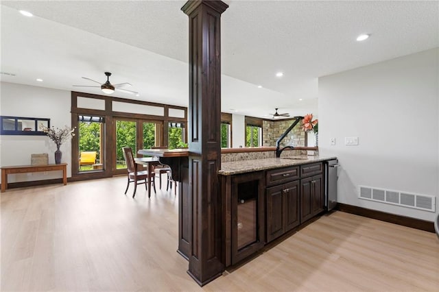 15405 161st St, Bonner Springs, KS 66012 - kitchen featuring a ceiling fan, light wood-type flooring, dark brown cabinets, light stone counters, and recessed lighting