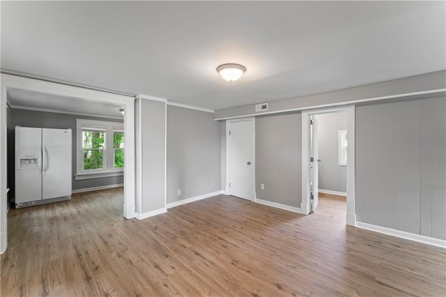 115 Brown Ave, Osawatomie, KS 66064 - spare room featuring wood finished floors, crown molding, and baseboards