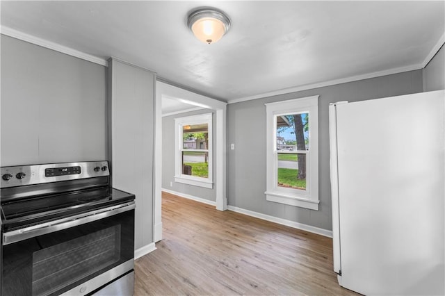 115 Brown Ave, Osawatomie, KS 66064 - kitchen with freestanding refrigerator, electric range, light wood-type flooring, baseboards, and crown molding