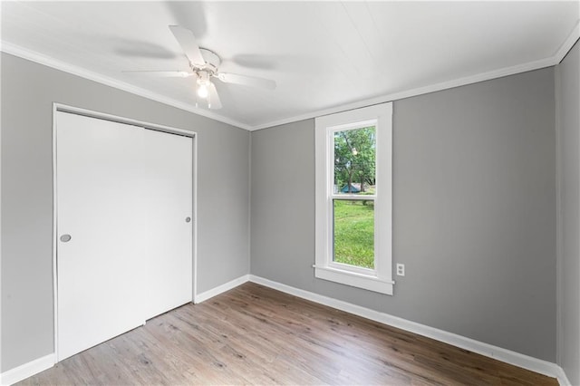 115 Brown Ave, Osawatomie, KS 66064 - unfurnished bedroom with wood finished floors, ornamental molding, baseboards, a closet, and a ceiling fan