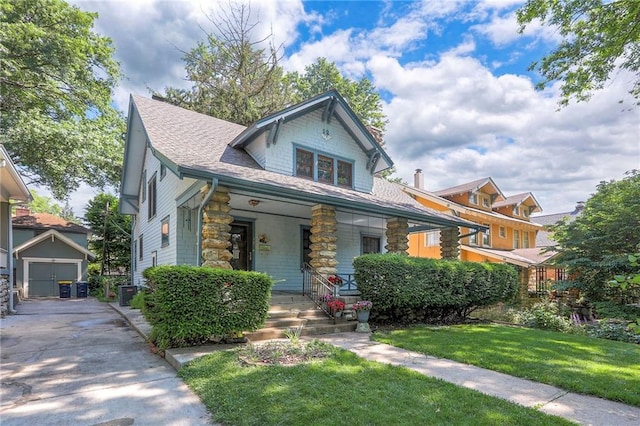 12 W 57th Ter, Kansas City, MO 64113 - view of front of home featuring covered porch, a front lawn, stone siding, a shingled roof, and concrete driveway