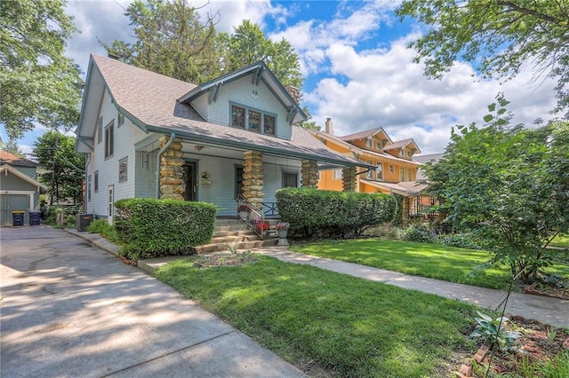 12 W 57th Ter, Kansas City, MO 64113 - view of front of home featuring covered porch, stone siding, a front lawn, and a shingled roof