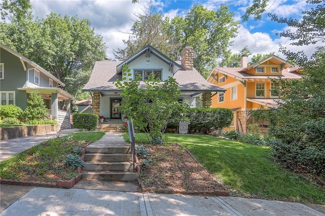 12 W 57th Ter, Kansas City, MO 64113 - view of front of house featuring a front lawn, stone siding, and a chimney