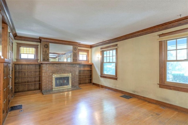 12 W 57th Ter, Kansas City, MO 64113 - unfurnished living room featuring ornamental molding, wood finished floors, plenty of natural light, and a fireplace