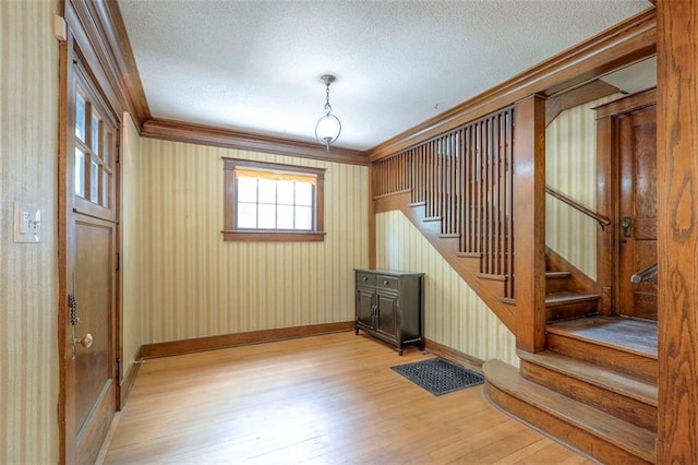 12 W 57th Ter, Kansas City, MO 64113 - staircase with wood finished floors, crown molding, and a textured ceiling