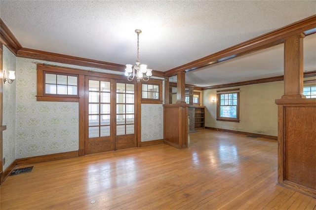 12 W 57th Ter, Kansas City, MO 64113 - unfurnished dining area featuring crown molding, a chandelier, hardwood / wood-style flooring, french doors, and a textured ceiling