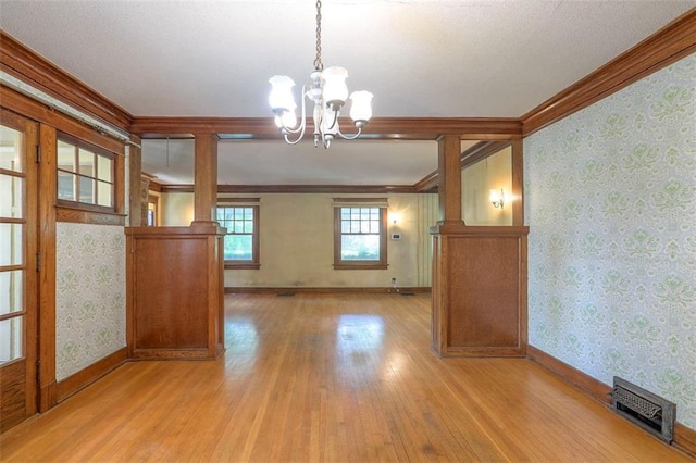 12 W 57th Ter, Kansas City, MO 64113 - unfurnished dining area with ornamental molding, light wood-style flooring, a chandelier, and wallpapered walls