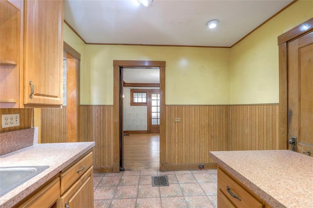12 W 57th Ter, Kansas City, MO 64113 - kitchen featuring a wainscoted wall, light countertops, crown molding, and light tile patterned flooring
