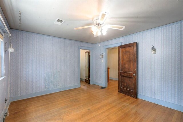 12 W 57th Ter, Kansas City, MO 64113 - empty room featuring wood finished floors, a ceiling fan, and wallpapered walls