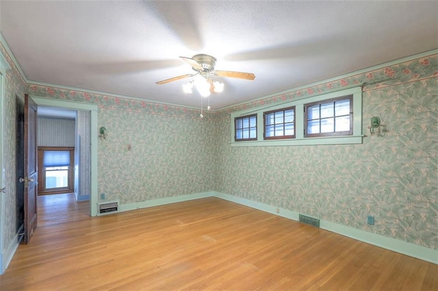12 W 57th Ter, Kansas City, MO 64113 - empty room featuring light wood finished floors, ceiling fan, and wallpapered walls