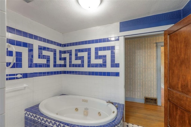 12 W 57th Ter, Kansas City, MO 64113 - full bathroom featuring a whirlpool tub, wood finished floors, and a textured ceiling