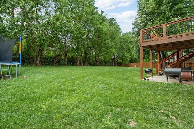 3223 SW Amber Ct, Lees Summit, MO 64082 - view of yard with a trampoline, a patio area, a wooden deck, and stairway