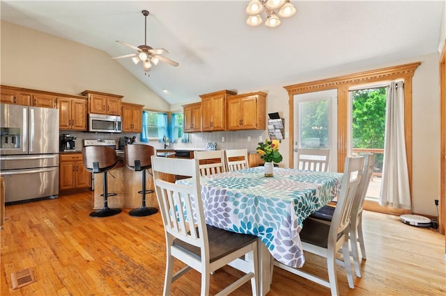 3223 SW Amber Ct, Lees Summit, MO 64082 - dining area with a ceiling fan, vaulted ceiling, and light wood-style flooring