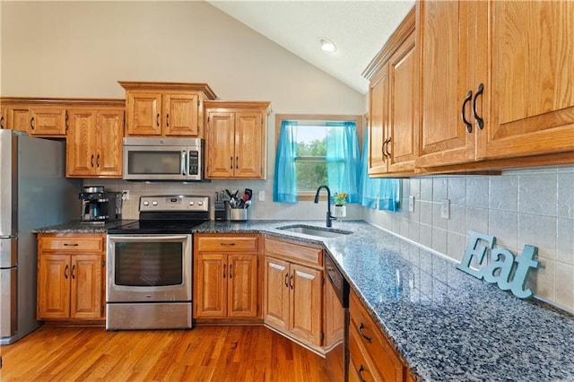 3223 SW Amber Ct, Lees Summit, MO 64082 - kitchen with stainless steel appliances, a sink, decorative backsplash, brown cabinetry, and high vaulted ceiling