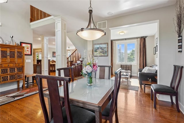 22404 S Roosevelt St, Spring Hill, KS 66083 - dining space featuring decorative columns, wood finished floors, stairs, and baseboards