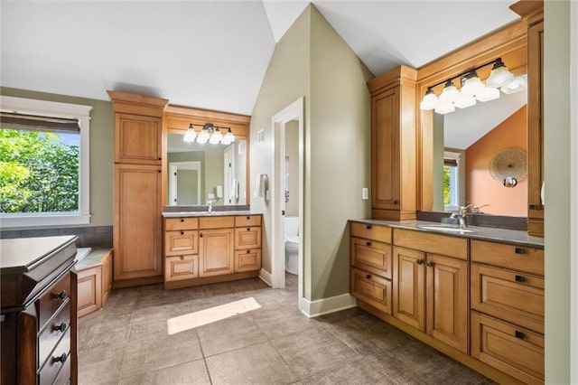 22404 S Roosevelt St, Spring Hill, KS 66083 - bathroom featuring vaulted ceiling, two vanities, toilet, tile patterned floors, and baseboards