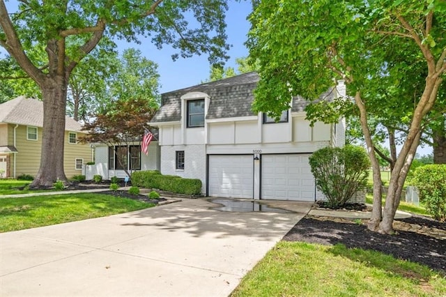 5000 W 96th St, Overland Park, KS 66207 - view of front facade with roof with shingles, concrete driveway, a garage, brick siding, and a front yard