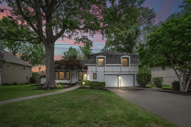5000 W 96th St, Overland Park, KS 66207 - front facade featuring mansard roof, a shingled roof, a garage, concrete driveway, and a front lawn