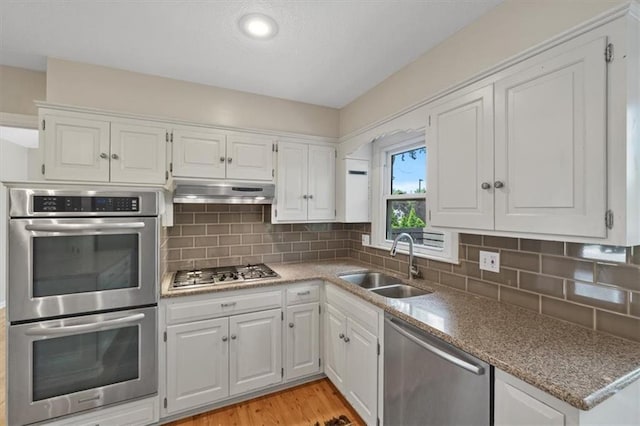 5000 W 96th St, Overland Park, KS 66207 - kitchen with appliances with stainless steel finishes, a sink, under cabinet range hood, white cabinetry, and recessed lighting