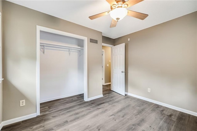 5912 E 98th St, Kansas City, MO 64134 - unfurnished bedroom with wood finished floors, baseboards, a closet, and ceiling fan