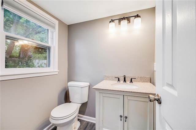 5912 E 98th St, Kansas City, MO 64134 - bathroom featuring toilet, vanity, baseboards, and wood finished floors