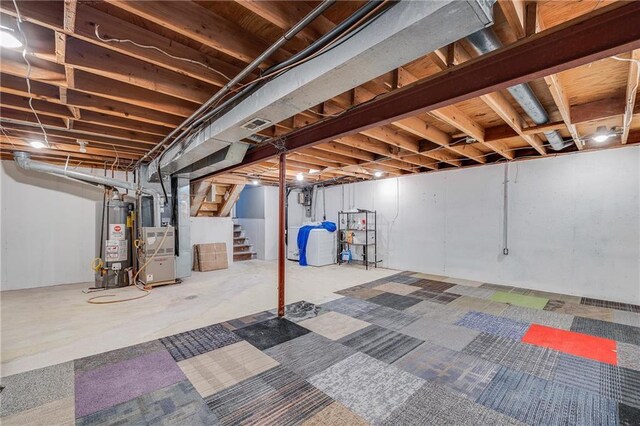 5912 E 98th St, Kansas City, MO 64134 - unfinished below grade area with gas water heater, stairway, and heating unit