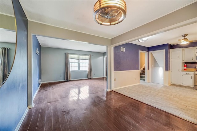 5912 E 98th St, Kansas City, MO 64134 - unfurnished living room with stairs, light wood-style floors, and baseboards