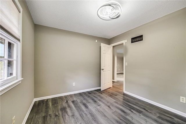 5912 E 98th St, Kansas City, MO 64134 - empty room featuring wood finished floors, baseboards, and a textured ceiling
