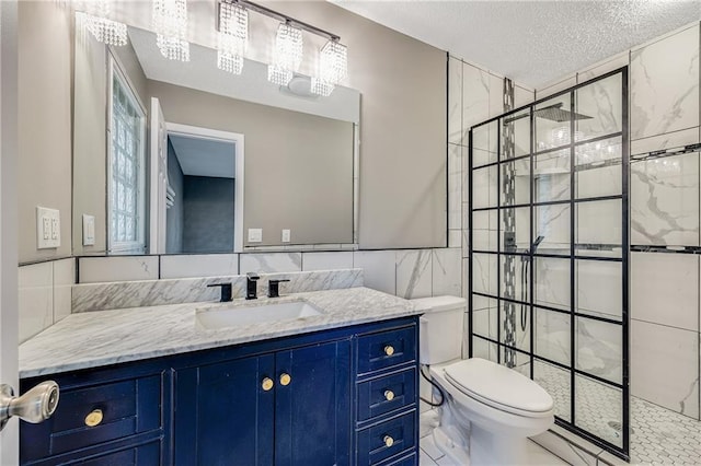 5912 E 98th St, Kansas City, MO 64134 - full bath with toilet, a tile shower, vanity, a textured ceiling, and tile walls