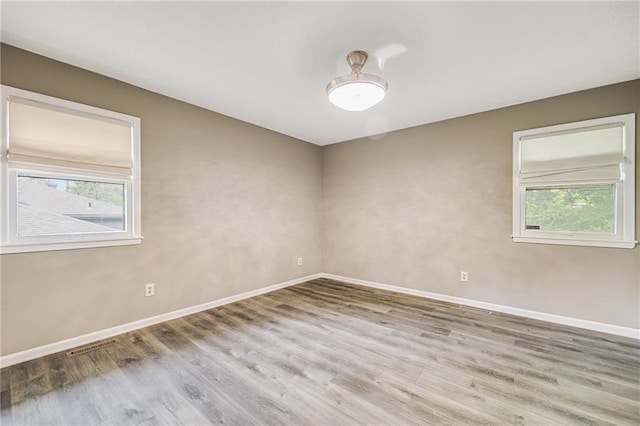 5912 E 98th St, Kansas City, MO 64134 - unfurnished room featuring plenty of natural light, baseboards, and wood finished floors