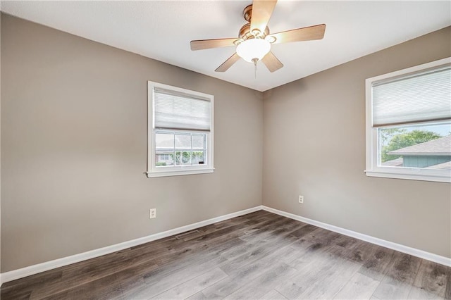 5912 E 98th St, Kansas City, MO 64134 - empty room featuring healthy amount of natural light, wood finished floors, and baseboards