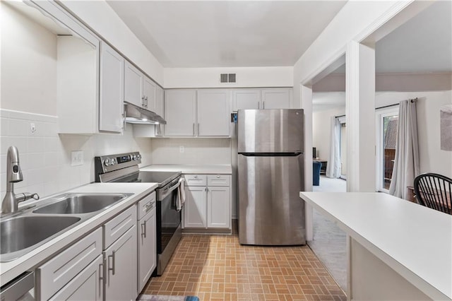7616 W 59th Ter Unit 37, Overland Park, KS 66202 - kitchen featuring appliances with stainless steel finishes, under cabinet range hood, a sink, brick patterned floors, and light countertops