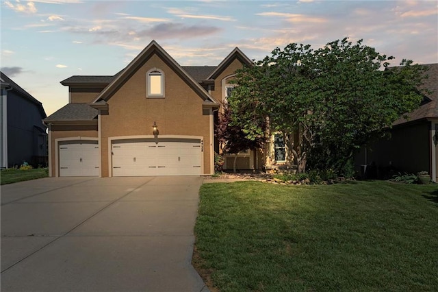 4528 N 108th St, Kansas City, KS 66109 - view of front of home with concrete driveway, a lawn, and stucco siding