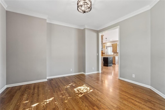 4528 N 108th St, Kansas City, KS 66109 - unfurnished room featuring wood finished floors, crown molding, baseboards, and a chandelier
