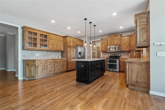 4528 N 108th St, Kansas City, KS 66109 - kitchen featuring appliances with stainless steel finishes, a center island, brown cabinets, decorative backsplash, and recessed lighting