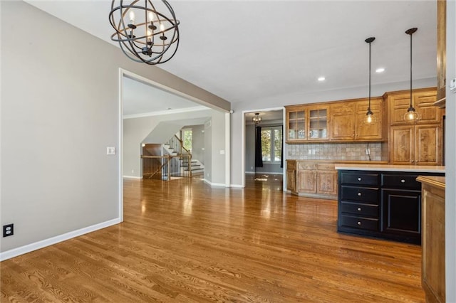 4528 N 108th St, Kansas City, KS 66109 - kitchen with a chandelier, baseboards, wood finished floors, light countertops, and brown cabinets