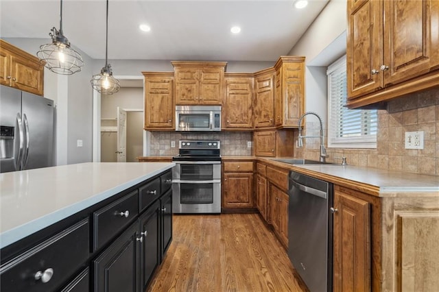 4528 N 108th St, Kansas City, KS 66109 - kitchen with stainless steel appliances, a sink, light wood-type flooring, light countertops, and hanging light fixtures