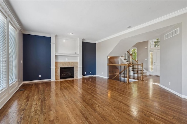 4528 N 108th St, Kansas City, KS 66109 - unfurnished living room featuring stairs, wood finished floors, baseboards, a tile fireplace, and ornamental molding