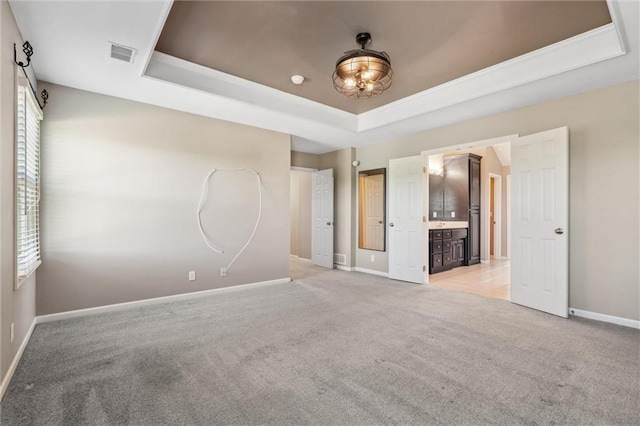 4528 N 108th St, Kansas City, KS 66109 - unfurnished bedroom with a raised ceiling, light colored carpet, baseboards, and connected bathroom