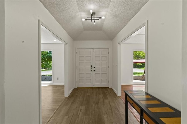 1038 N Woodland Ct, Oakwood, MO 64118 - entrance foyer featuring wood finished floors, lofted ceiling, a textured ceiling, and baseboards