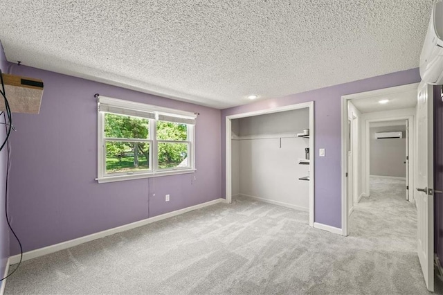 1038 N Woodland Ct, Oakwood, MO 64118 - unfurnished bedroom with carpet floors, a wall unit AC, a closet, a textured ceiling, and baseboards