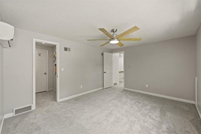 1038 N Woodland Ct, Oakwood, MO 64118 - unfurnished bedroom featuring carpet floors, a wall unit AC, baseboards, ceiling fan, and a textured ceiling